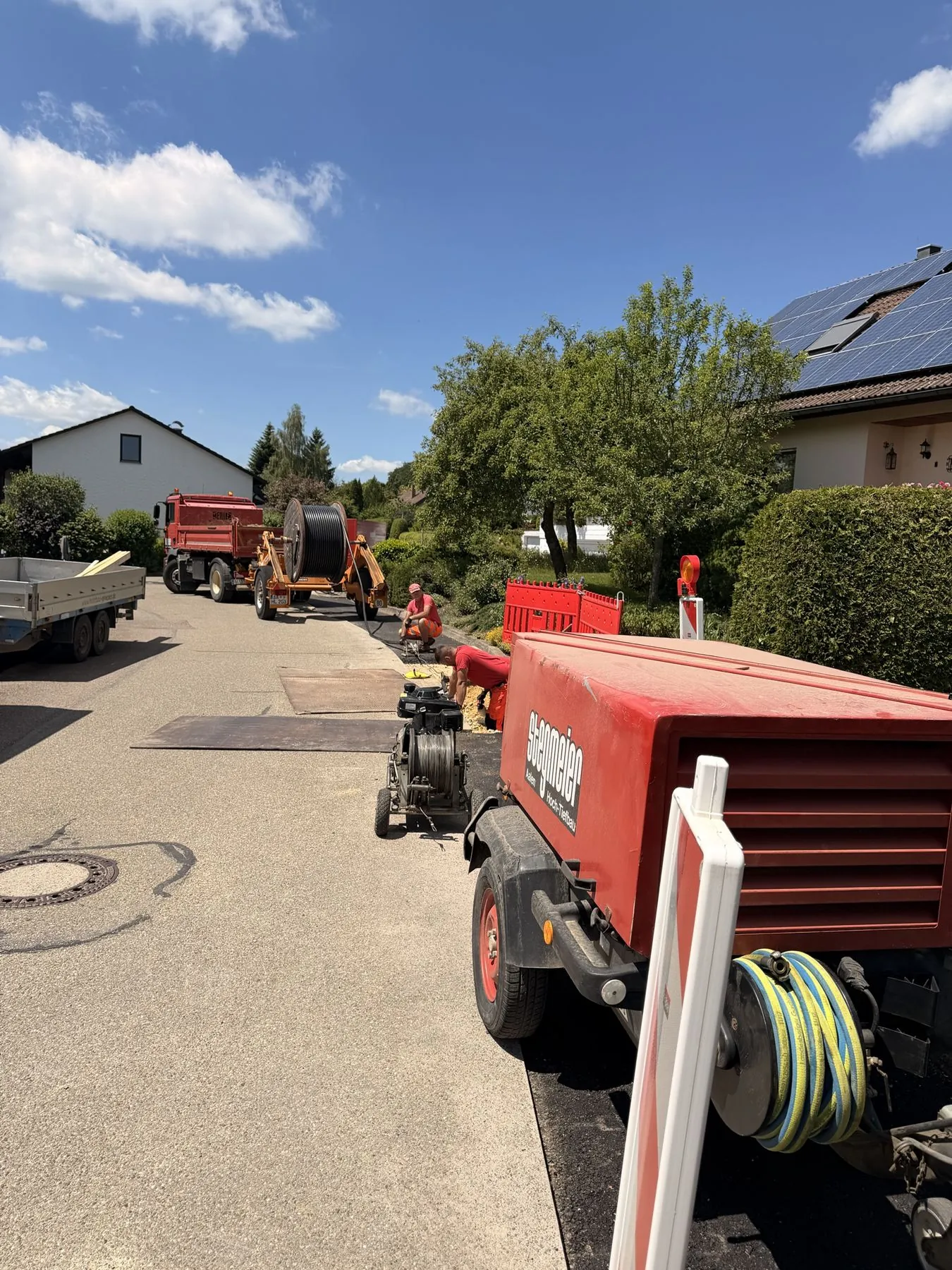 Kabeltrommel und Kompressor beim Kabelzug im Wohngebiet