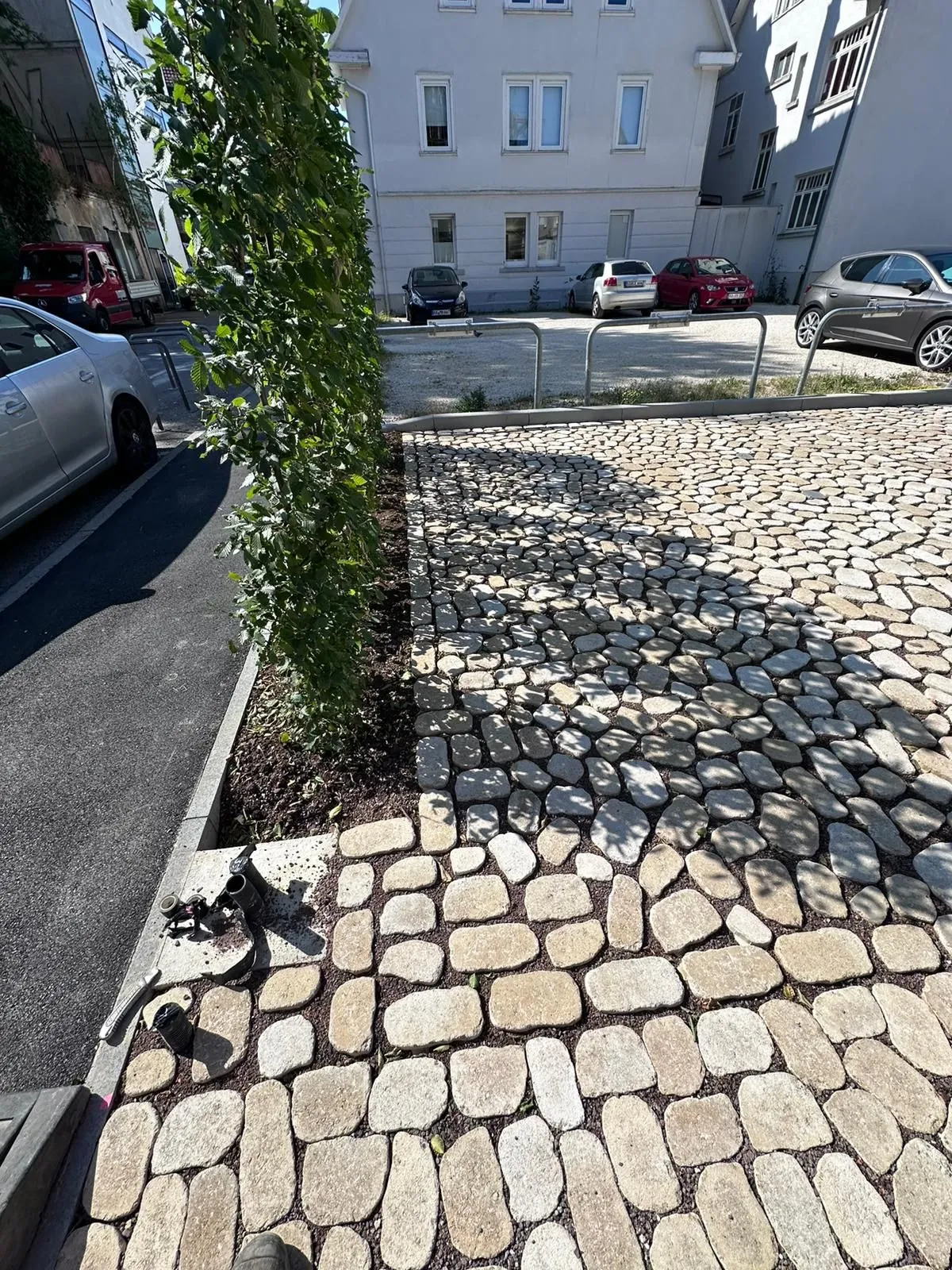 Neues Pflaster mit Hecke und Stellplätzen