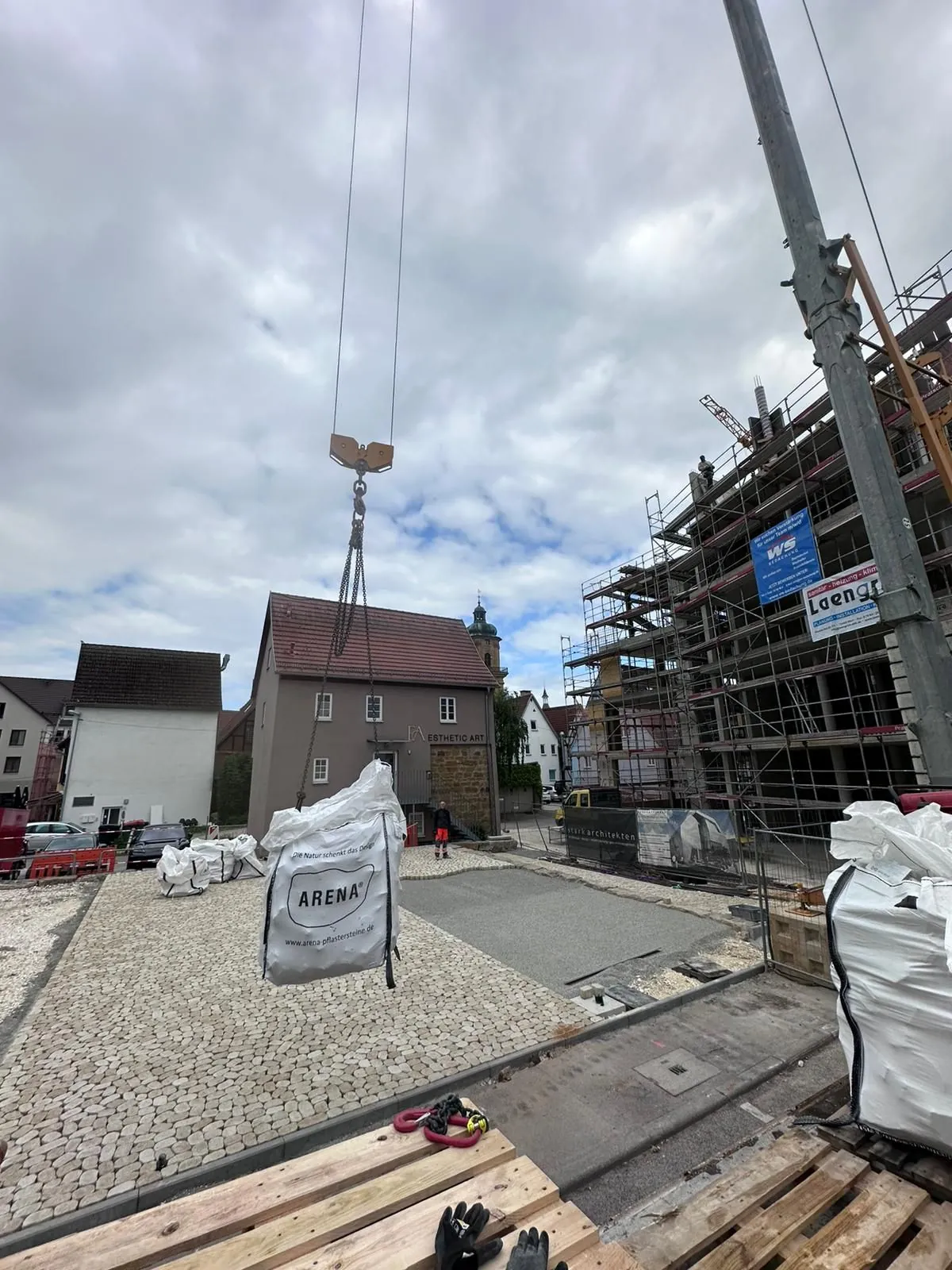 Kran hebt Pflastersteine auf die Baustelle